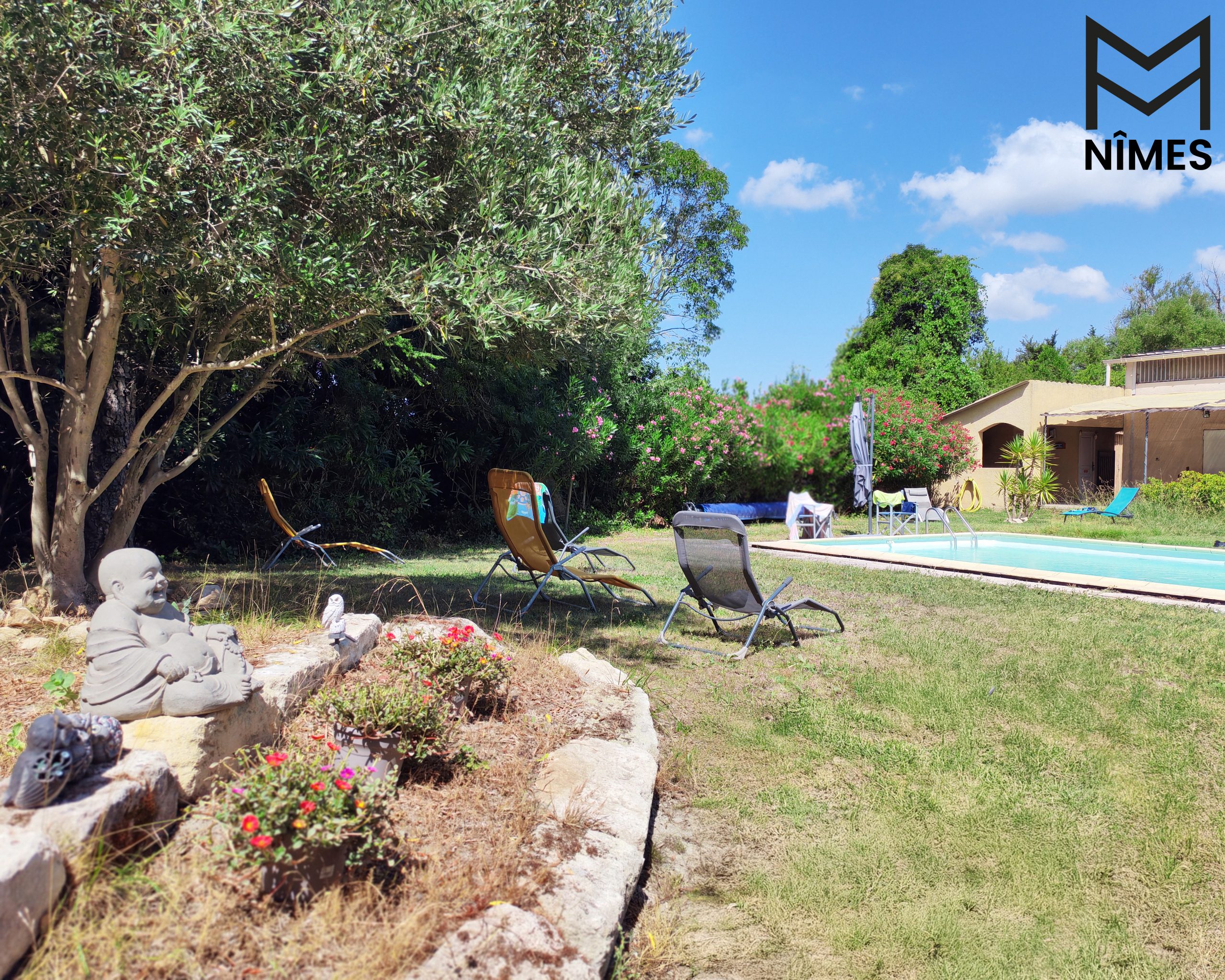 Au cœur du jardin, le Bouddha veille en paix, symbole de sérénité et de contemplation.