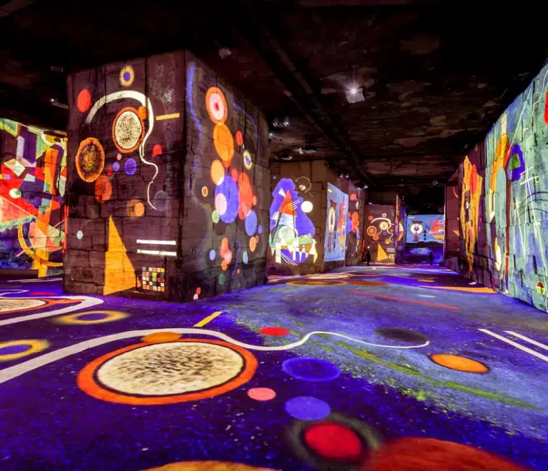 Exposition immersive avec projections colorées sur murs.