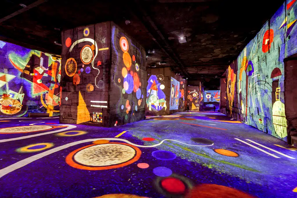 Exposition immersive avec projections colorées sur murs.