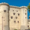 Château médiéval avec tours imposantes en pierre.
