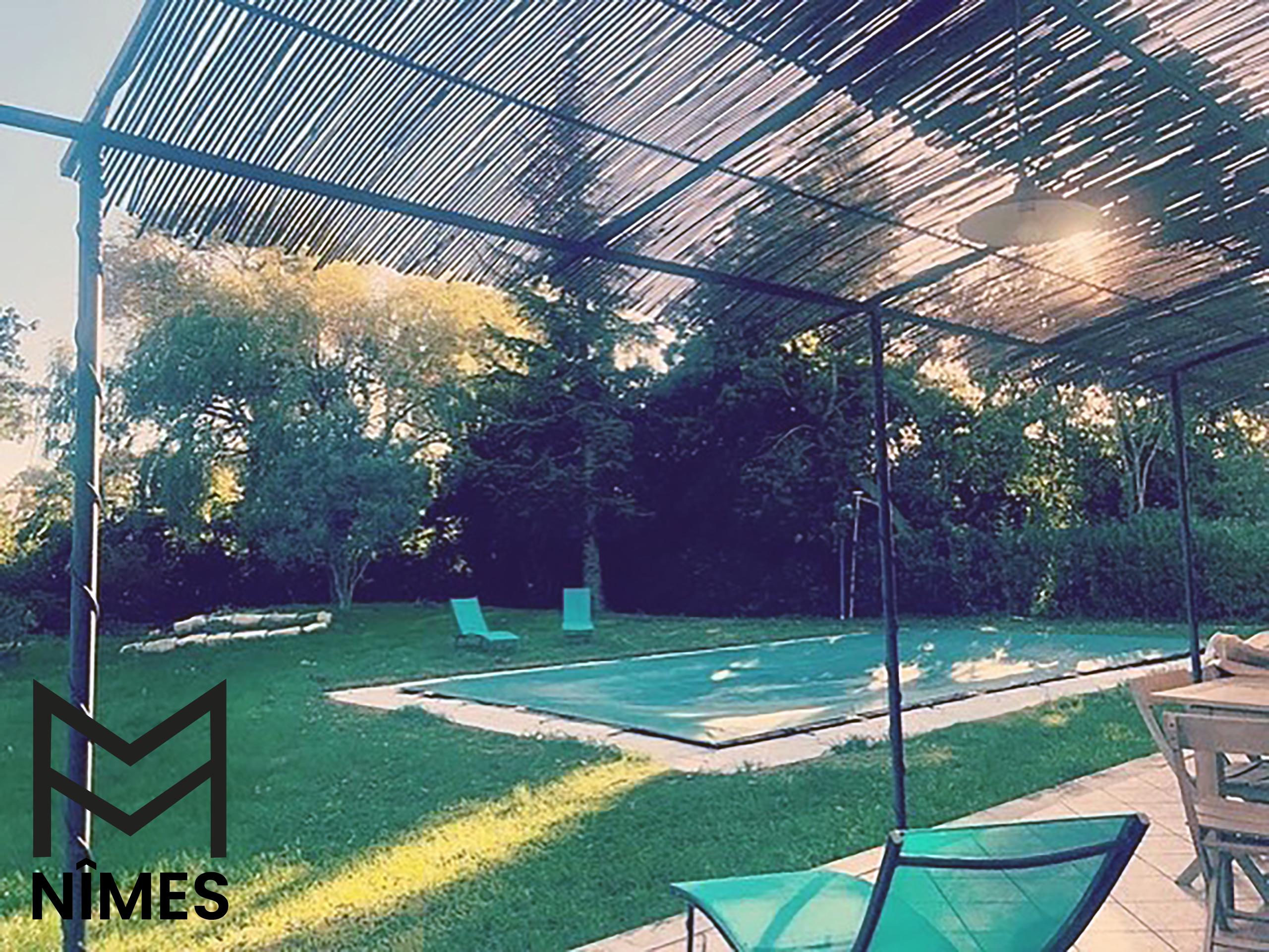 Depuis la terrasse des hôtes, vue vaste sur la piscine et le jardin, sensation d’espace.