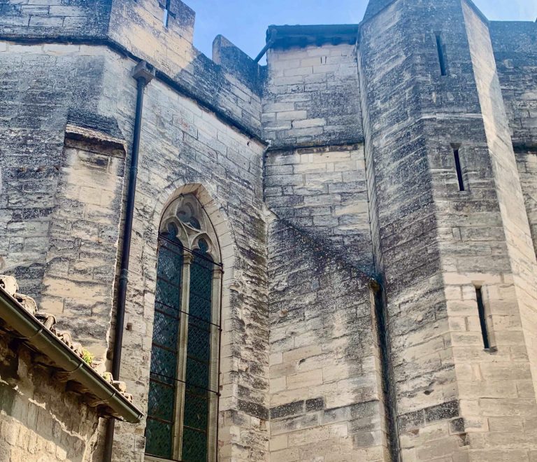 Mur médiéval en pierre avec grande fenêtre.