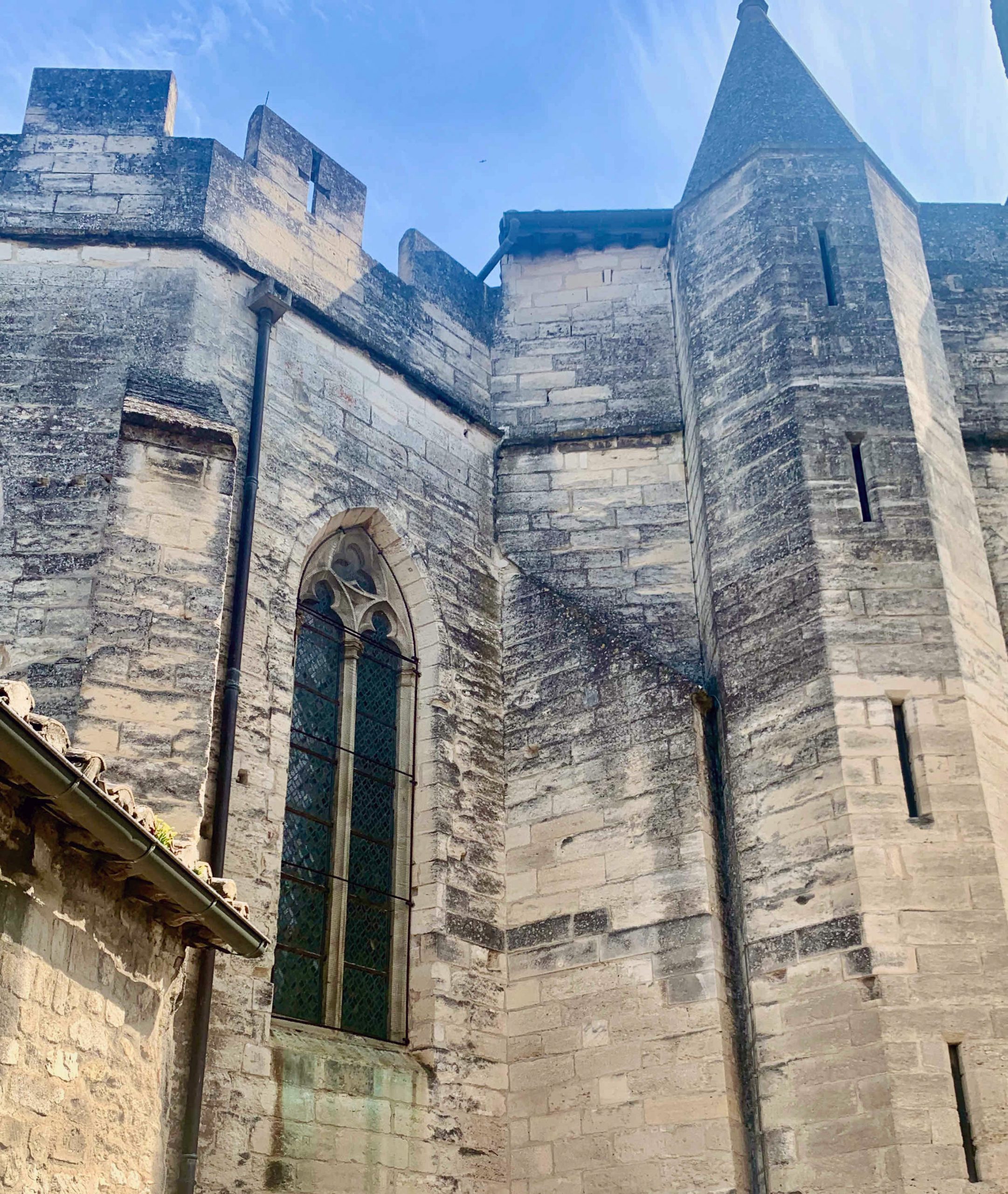 Mur médiéval en pierre avec grande fenêtre.